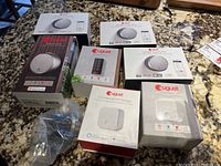 Seven August branded retail boxes including smart locks, keypad, and bridges on countertop