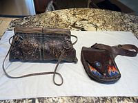 Overview of both items together on a white surface showing clutch and belt bag with embroidery and belt strap.