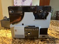 Front and side view of the Kodak Instamatic M109 projector showing main controls and casing.