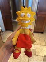 Full frontal image of Lisa Simpson plush doll with detailed view of face and outfit.
