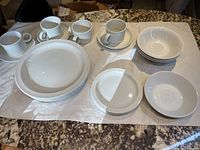 Overview of all items including dinner plates, side plates, bowls, teacups, and saucers laid out on a cloth.