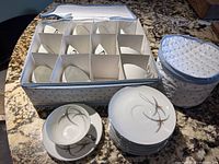 Tea set in original fabric storage container with 12 cups and 12 saucers stacked neatly.