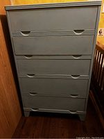 Front view of the chest showing all five drawers with integrated handle grooves and distressed paint