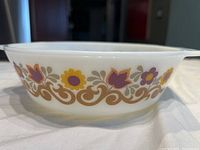 Side view of vintage Pyrex casserole showing floral Briarwood pattern on white glass.
