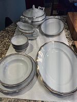 Image showing the full vintage Favolina serving set arranged on a granite countertop with tureen, platters, gravy boat, ladle, bowls, and plate.