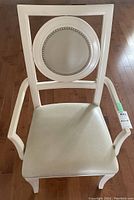 Front view of white armchair showing seat cushion and oval backrest