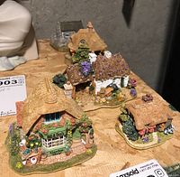 Front group shot of four miniature cottages: Bill & Ben’s Garden Shop, two thatched roof cottages and a stone cottage