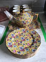 Full set on counter showing teapot, tray, cups and saucers