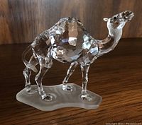 Front and side angle of crystal camel figurine showing faceted body and frosted base.