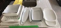 Wide shot of white ceramic serving platters and baking dishes from Maxwell Williams and Pozzani, arranged on counter.