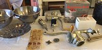 Overview of food grinder, sausage stuffer, manual chopper parts, and metal steam baskets.