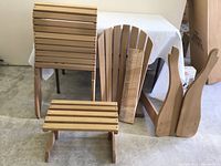 Unassembled chair pieces and assembled footstool on floor