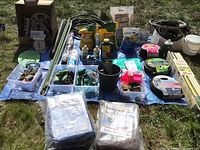 Overall lot laid on blue tarp showing hoses, reels, bags and bins of fittings