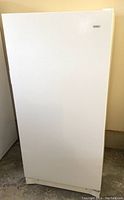 Front view of white upright freezer with Kenmore logo on door.