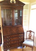 Full view of the mahogany secretary desk with glass upper cabinet and matching vintage chair