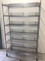 Front angled view of the metal rolling wire rack, showing all six shelves and caster wheels.