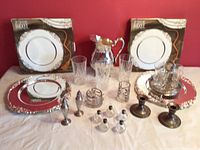 Full overview of set showing plates in boxes, pitcher, glasses, tray, cordial glasses, sugar bowl, creamer, candlesticks, salt and pepper shakers.