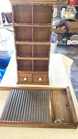 Front view of wooden curio shelf and wooden washboard.