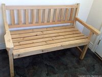 Front side view showing the natural pine finish, slatted seat, and armrests.