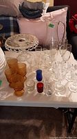 Photo showing amber stemmed glasses, pedestal cake plate, clear glasses, small colored glasses and clear glass pitcher