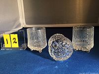 Set of three clear textured glass shot glasses showing front and side angles with a ruler for size reference