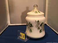 Front view of satin finish cookie jar displaying floral design and lid with frosted knob.