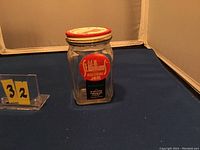 Front view of the empty St. Williams jam jar showing original label and red and white lid with price markings.