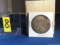 Front (obverse) side of 1926 silver dollar showing Lady Liberty profile with the word Liberty and date visible, in coin holder with block and numbered label.