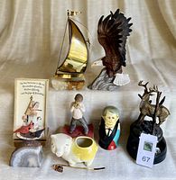 Full view of all decorative items including Russian dolls, brass sailboat, deer figurines, eagle, geode, and other small pieces arranged on a surface.