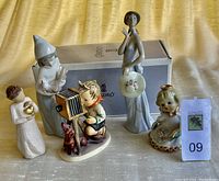 Group photo of all five collectible figurines together, showing variety in size and style.