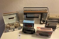 Full lot showing vintage reel to reel recorder, 3 transistor radios, 2 mini boombox radios (one boxed), and clock radio in box