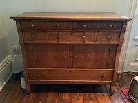 Front view of the solid wood antique buffet showing drawers and cabinet doors.