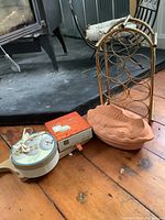 Photo showing terra cotta fish-shaped roaster, brass wine rack, small dipping plates with ribbon, cheese board, porcelain plate set box.