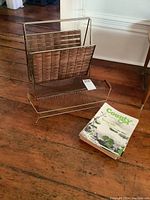 Wide view showing both metal racks and a stack of County magazines on a wooden floor