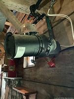 Side view of black metal Leko theatre spotlight mounted, showing overall condition and mounting bracket.