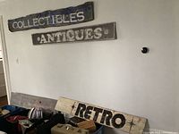 Four barn wood plank signs visible, with 'RETRO' and a heavily faded vintage sign on planks laid on table.