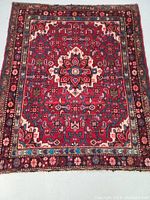Top view of the Persian rug showing center floral medallion and decorative border in rich colors.