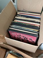 Box filled with a large number of vinyl records, tops visible including Die Fledermaus album in front.