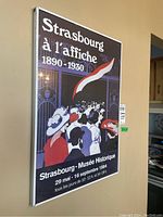 Full view of framed print showing artwork and title 'Strasbourg à l'affiche 1890-1930' with detail of crowd scene illustration.