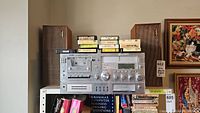Wide view of Yorx stereo receiver and Realistic Solo-4 speakers with 8-track tapes on top