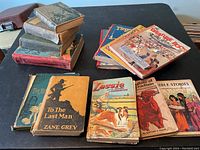 Photo showing a group of vintage hardcover children's books including 'To The Last Man', Lassie, Bible Stories, Treasure Book, and others
