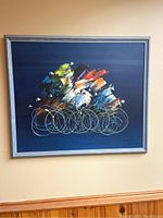 Full frontal view of painting with silver frame against wall