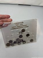 Top view of plastic display holder showing Canadian 125th Anniversary Commemorative Coins from 1867 to 1992, including several provincial coins.
