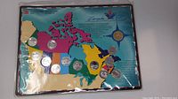 Set of twelve quarters arranged on a colorful map of Canada, with each quarter depicting a province and mounted in a protective holder.