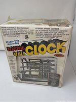 Front of box with SNAP-FIT Assembly Electric Ball Clock branding and assembly diagram