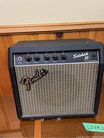 Front-facing view of amplifier showing grille cloth, Fender logo and control panel.