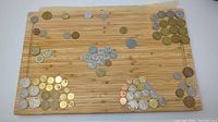 Overview photo of assorted coins grouped by size and color on wooden board