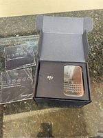 Opened box with Bold 9000 smartphone in packaging and English/French Getting Started guides laid out