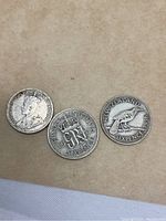 Three New Zealand Sixpence coins, dated 1936, 1939, and one with kiwi bird design