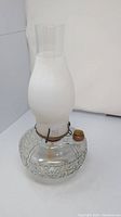 Full view of the vintage B&H Bradley Hubbard oil lamp showing clear textured glass base, frosted glass chimney, and brass fittings.